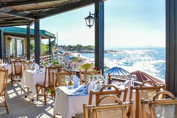 Außenterrasse des Creta Star Hotels mit Blick auf das Meer und einen Strand.