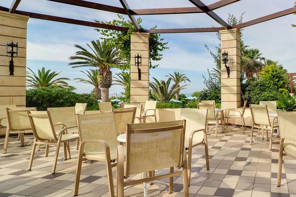 Außenterrasse des Creta Star Hotels mit gemustertem Boden und vielen Stühlen.