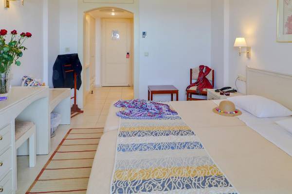 Hotelzimmer im Creta Star mit zwei Betten, Dekor und Möbeln.