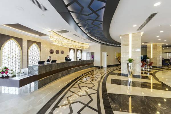 Empfangsbereich des Dream World Hill Hotels mit Rezeption, Lampen und Marmorboden