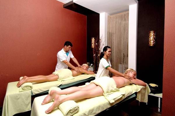 Spa-Behandlung im Seamelia Beach Resort & Spa mit zwei Frauen, die Massagen erhalten.
