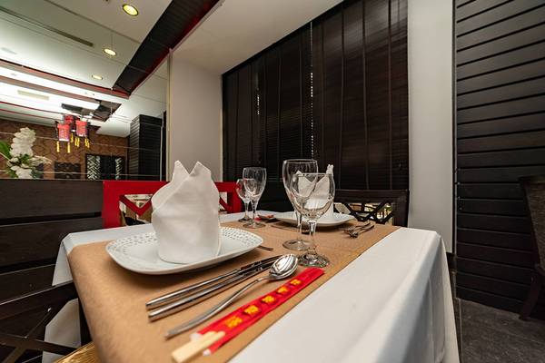 Tisch im Hotelrestaurant des Seamelia Beach Resort & Spa mit Platzkarten, Besteck und Gläsern.