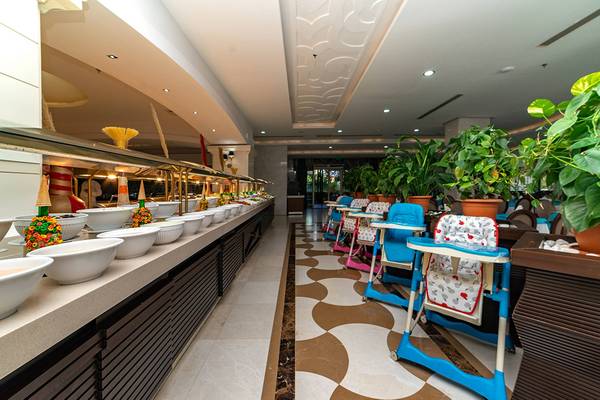 Restaurantbereich im Seamelia Beach Resort & Spa mit vielen Speisen auf einer Theke und Kinderhochstühlen