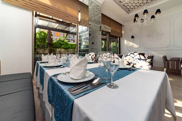 Gedeckter Tisch im Restaurant des Seamelia Beach Resort & Spa mit Blick auf den Garten.