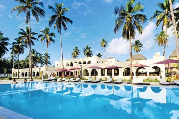 Außenpool des Bahari Zanzibar Hotels mit Loungestühlen und Sonnenschirmen.