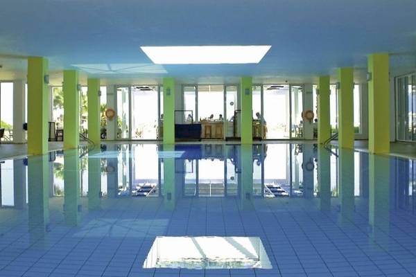 Innenpool des Royal & Imperial Belvedere Hotels mit blauen Fliesen und gelben Säulen.