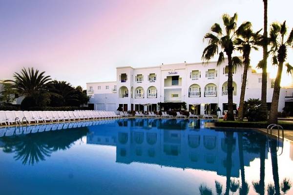 Außenpool des Royal Decameron Tafoukt Beach Hotels mit weißen Sonnenliegen und Palmen.