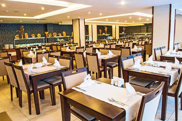 Innenansicht des Restaurants des Sun Beach Park & Spa Hotels mit gedeckten Tischen und Stühlen.