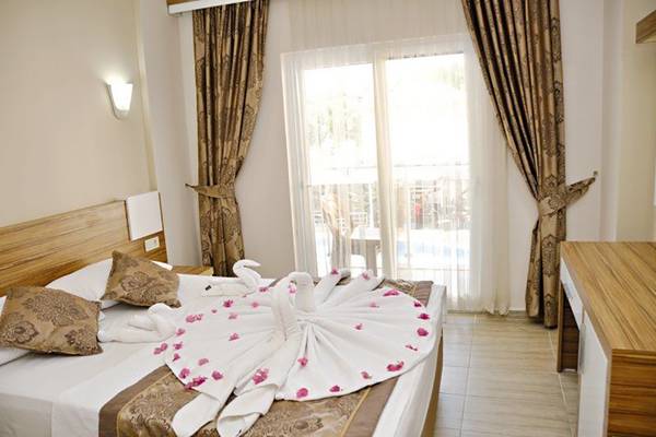 Ein Hotelzimmer im Sun Beach Park & Spa mit einem Bett, das mit einem Handtuch-Schwanen-Arrangement dekoriert ist.