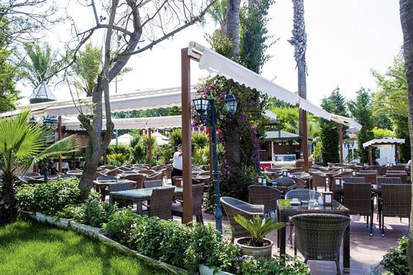 Gartenrestaurant im Sun Beach Park & Spa mit Tischen und Stühlen unter weißen Markisen.