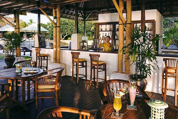 Bar im Freien des Jimbaran Puri Hotels in Bali mit Barkeeper und Cocktails.