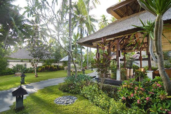 Außenbereich des Jimbaran Puri Hotels in Bali mit Garten und Gehweg