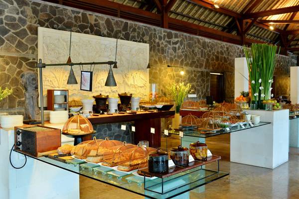 Frühstücksbuffet im Jimbaran Puri Hotel, Bali mit verschiedenen Gerichten und Früchten.