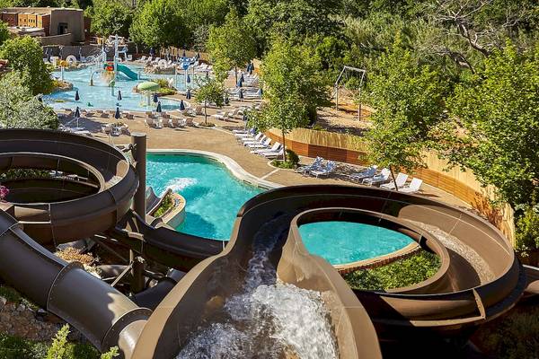 Wasserrutsche im Westin Resort, Costa Navarino, mit großem Pool und Sonnenliegen.