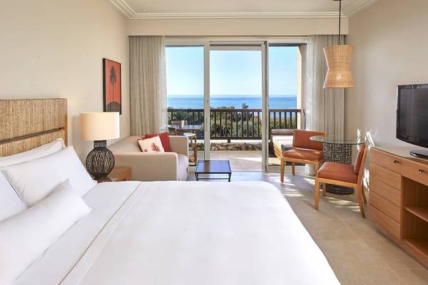 Suite im Westin Resort Costa Navarino mit Blick auf das Meer von einem Balkon aus.