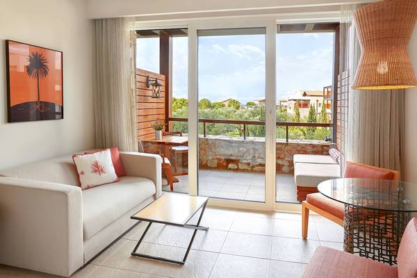 Innenbereich des Westin Resort, Costa Navarino mit Wohnzimmer und Terrasse.