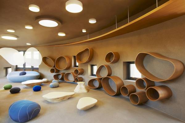 Innenbereich des Westin Resorts in Costa Navarino mit organischen Holzmöbeln und modernen Leuchten.
