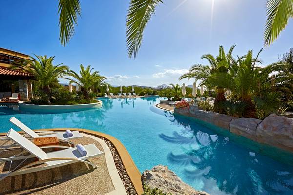 Außenpool mit Loungestühlen und Palmen im Westin Resort, Costa Navarino