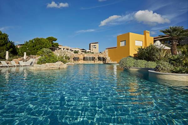 Außenpool des Westin Resorts in Costa Navarino mit gelbem Gebäude und Wasserfällen