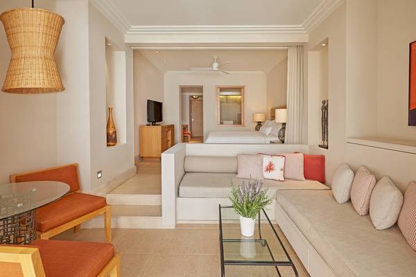 Innenansicht einer Hotelsuite im Westin Resort, Costa Navarino, mit einem Wohnzimmerbereich und einem Schlafzimmerbereich.