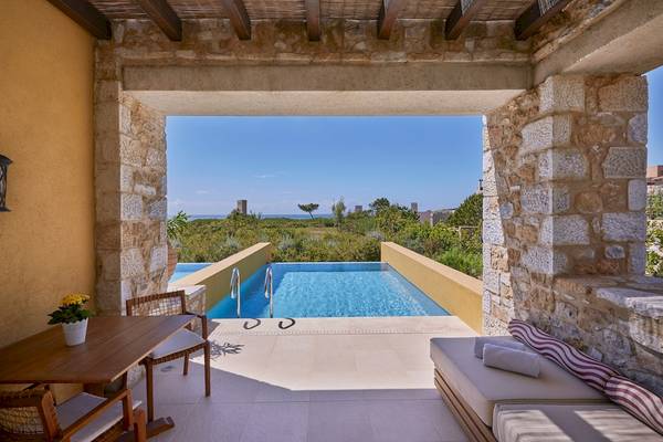 Terrasse mit Tisch und Pool im Westin Resort, Costa Navarino
