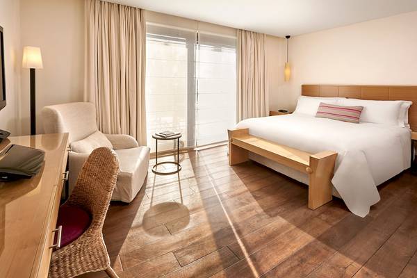 Hotelzimmer im Westin Resort, Costa Navarino mit Bett, Schreibtisch und Sitzmöbeln.