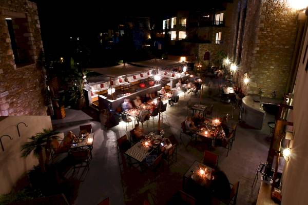 Einen Abendessenbereich im Westin Resort, Costa Navarino, mit vielen Gästen, die an Tischen sitzen und essen.