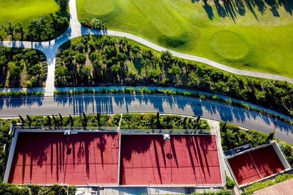 Aussenansicht des Westin Resorts Costa Navarino mit Tennisplätzen und einem Golfplatz