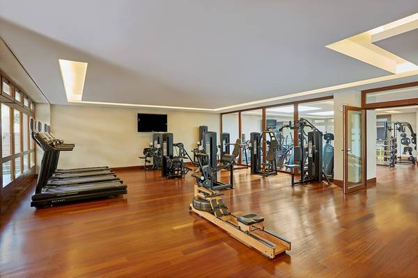 Fitnesscenter im Westin Resort, Costa Navarino mit Laufbändern, Gewichtsgeräten und einem Fernseher.