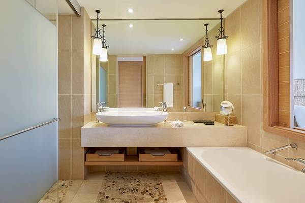 Badezimmer im Westin Resort, Costa Navarino mit großem Waschbecken und Badewanne.