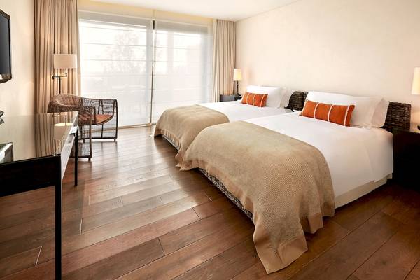 Doppelbett-Zimmer im Westin Resort, Costa Navarino mit moderner Einrichtung und Ausblick auf die Natur.