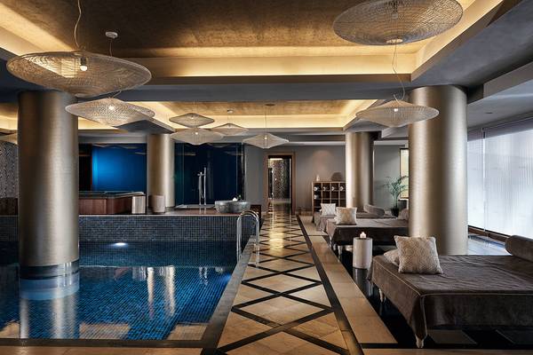 Innenpool im Domes of Elounda, Autograph Collection mit Liegen und modernen Lampen.