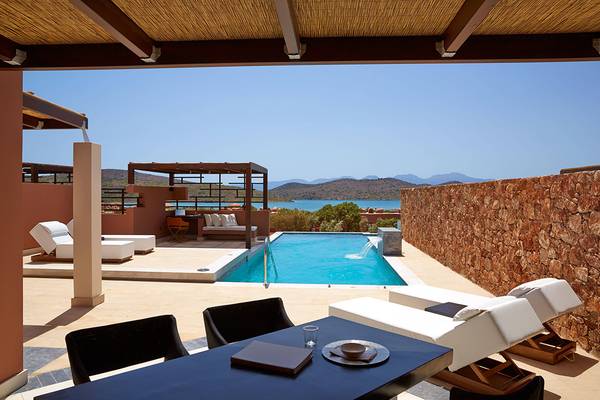 Außenterrasse des Domes of Elounda, Autograph Collection mit Pool und Blick auf das Meer.