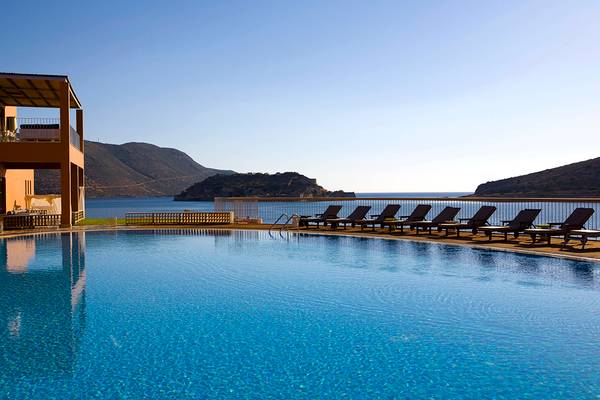 Außenpool des Domes of Elounda mit Blick auf das Meer und die Berge.