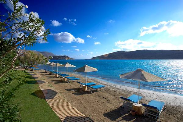 Domes of Elounda, Autograph Collection Strand mit Liegen und Sonnenschirmen