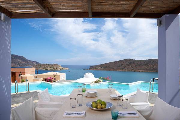 Terrasse des Domes of Elounda mit Blick auf das Meer und eine beleuchtete Einrichtung.