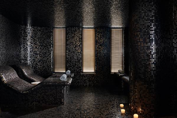 Spa-Bereich im Domes of Elounda, Autograph Collection mit schwarzen Mosaikfliesen und Liegestühlen.