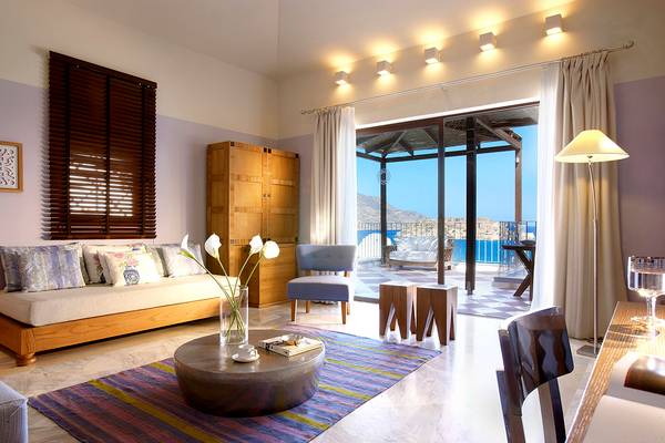 Wohnbereich im Domes of Elounda, Autograph Collection Hotel mit Blick auf den Balkon und das Meer.