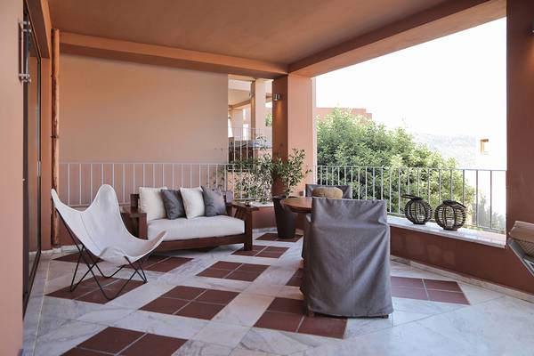 Balkon im Domes of Elounda, Autograph Collection mit Möbeln und Pflanzen.