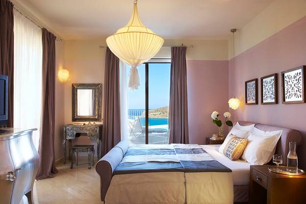 Schlafzimmer im Domes of Elounda, Autograph Collection Hotel mit Blick auf das Meer.