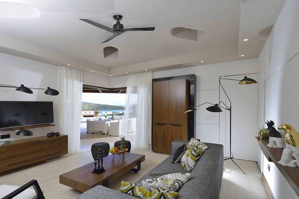 Innenansicht des Wohnzimmers im Domes of Elounda, Autograph Collection Hotel mit moderner Einrichtung.
