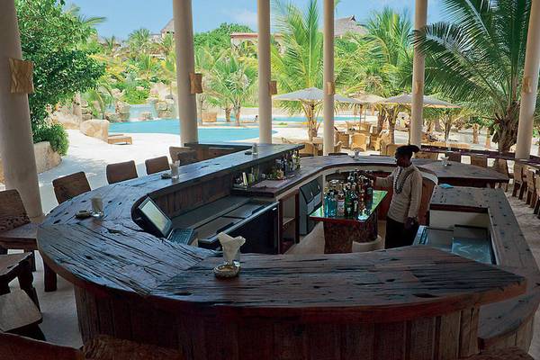 Bar im Swahili Beach Resort mit Blick auf den Pool und Palmen.
