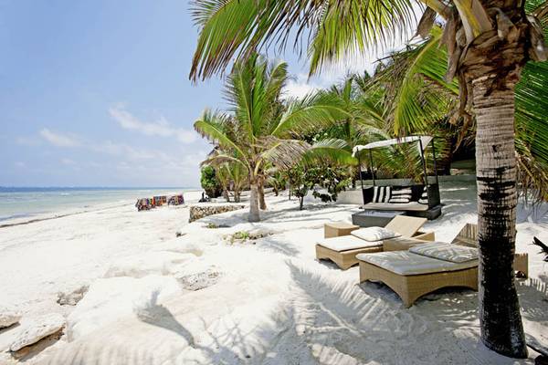 Strand des Swahili Beach Resorts mit Liegen und Palmen