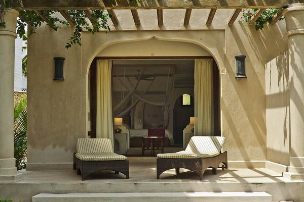 Terrasse des Swahili Beach Resorts mit zwei Liegen und Blick auf das Zimmer.