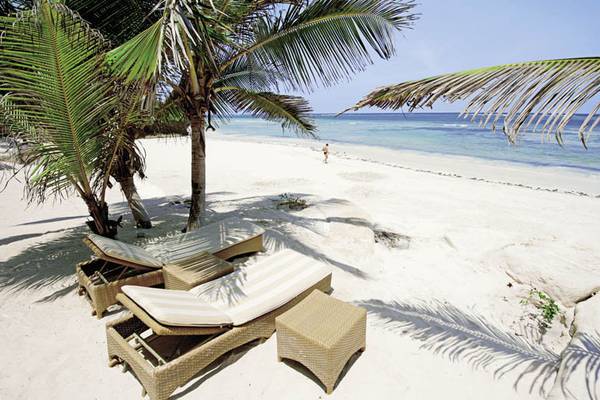 Loungebereich des Swahili Beach Resorts unter Palmen mit Blick auf den Strand