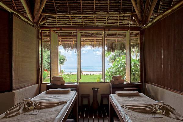 Massageraum im Sultan Sands Island Resort mit Blick auf das Meer und eine grüne Wiese.