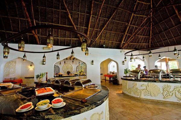 Innenbereich des Restaurants im Sultan Sands Island Resort mit verschiedenen Speisen und Gerichten, serviert an einem großen Tisch.