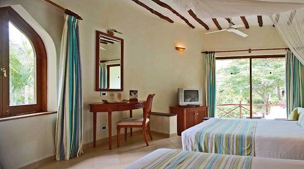 Doppelbett-Zimmer im Sultan Sands Island Resort mit zwei Betten, Schreibtisch, Fernseher und Aussicht.
