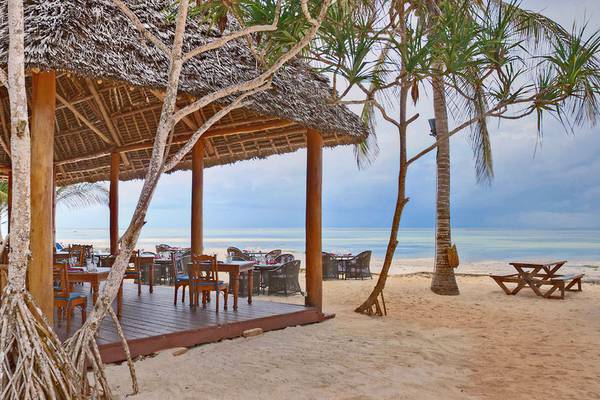 Außenbereich des Sultan Sands Island Resorts mit einem Restaurant am Strand und Palmen