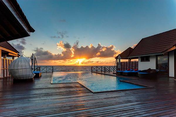 Sonnenuntergang am Pool des Robinson Maldives Hotels mit Blick auf das Meer.
